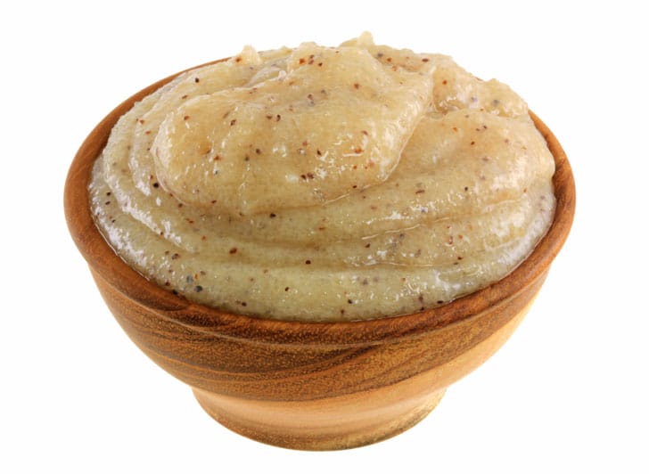 A wooden bowl filled with a mixture of brown sugar and cinnamon, ideal for an indulgent facial at a Japanese spa in Singapore.