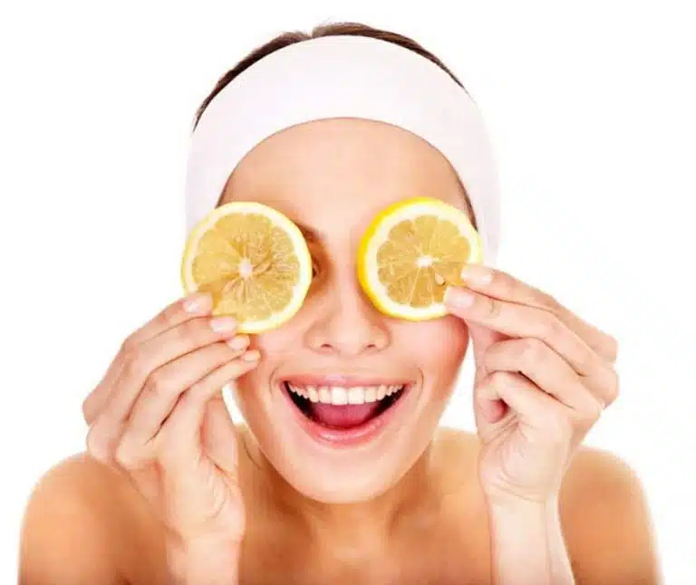 A person with a white headband holds two lemon slices over their eyes and smiles, celebrating Valentines 2017 against a plain white background.