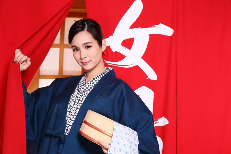 A woman in a Japanese kimono holding a box at a Japanese spa in Singapore.