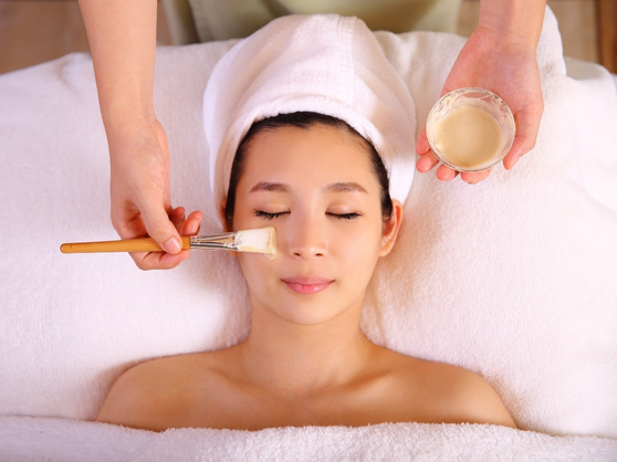 A woman is receiving a facial treatment at a Japanese spa in Singapore.