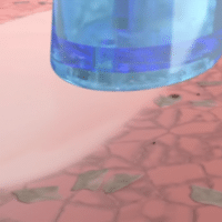 Close-up of a blue liquid container on a patterned surface with a few scattered dry leaves.