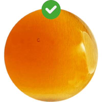 A round, glossy, orange-colored sphere with a green check mark above it resembles the serene glow of an onsen facial.