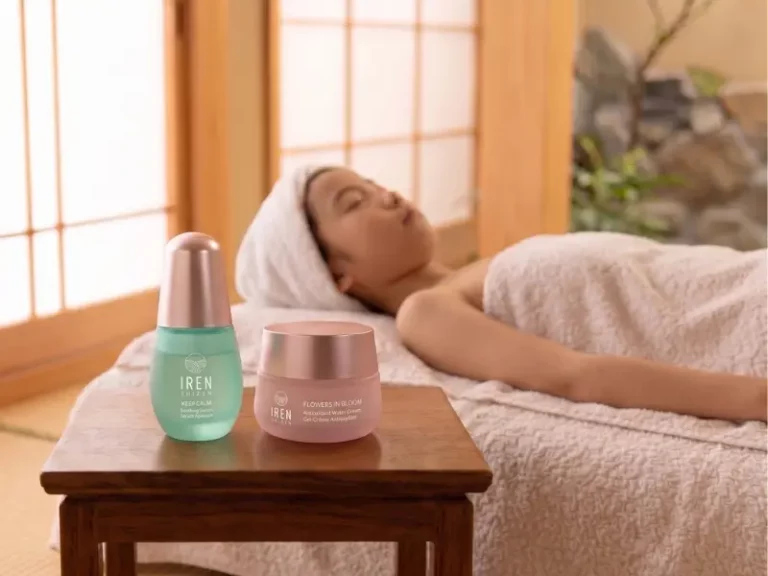 A person with a towel on their head lies on a spa bed, enjoying a moment of relaxation reminiscent of a kids’ facial. In the foreground, two skincare products are placed on a small wooden table.
