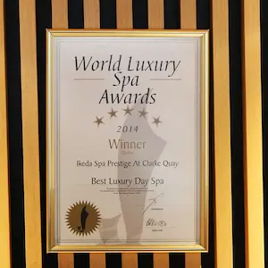 A framed certificate for the 2014 World Luxury Spa Awards, awarded to Ikeda Spa Prestige at Clarke Quay for Best Luxury Day Spa—a testament to their excellence and a must-see for anyone seeking an exclusive spa offer.